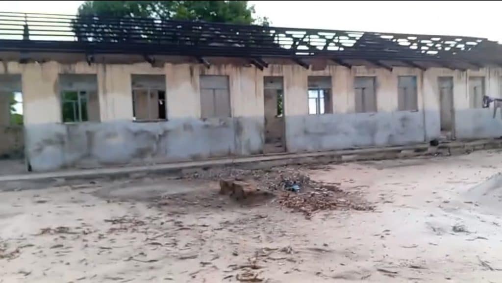 Abandoned primary school building with broken windows and a damaged roof, showing unsafe conditions for children’s education in a rural community.